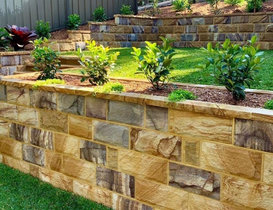 Garden retaining wall project using Aussietecture rockface ranch sandstone and copping stone.