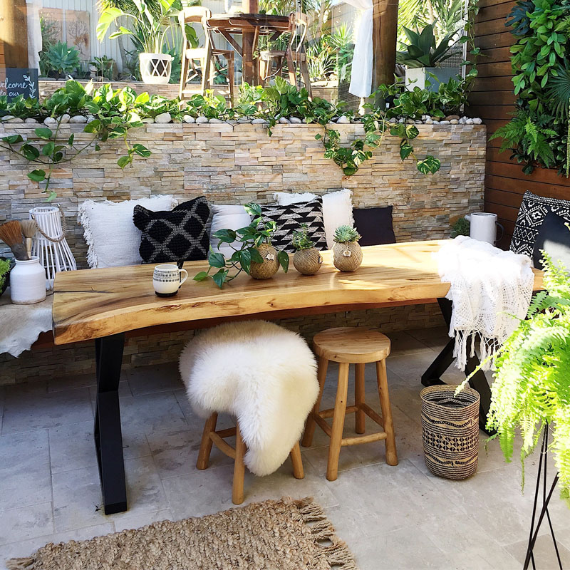 Outdoor entertaining area design of a residential house in Marrickville with a nice stone wall, cattail marble floor paver and some furniture