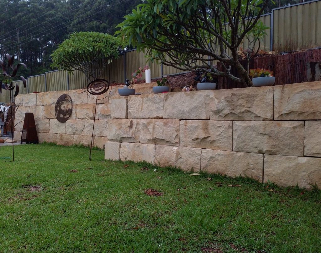 Australian sandstone logs used in a landscape project as retaining wall blocks