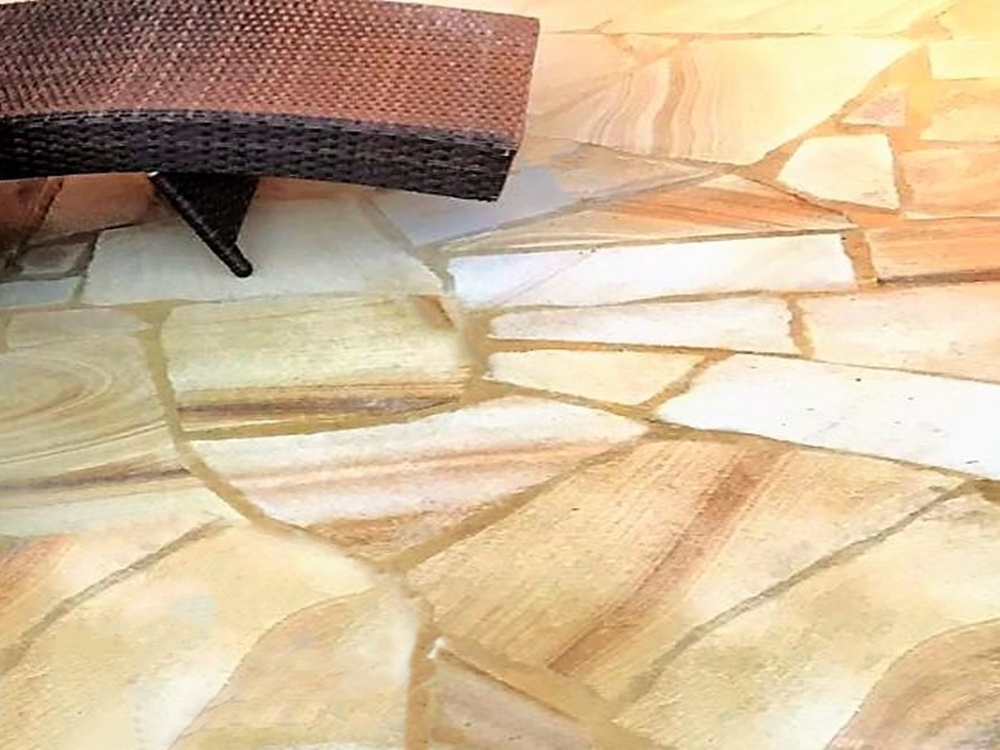 sandstone crazy paving in swimming pool area with a chair