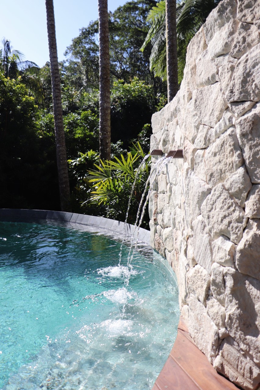 Foster Irregular Swimming pool project with curved sandstone wall water features